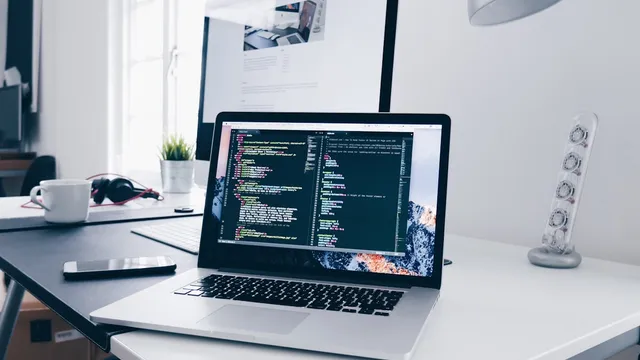 Developer workspace with laptop showing code on screen